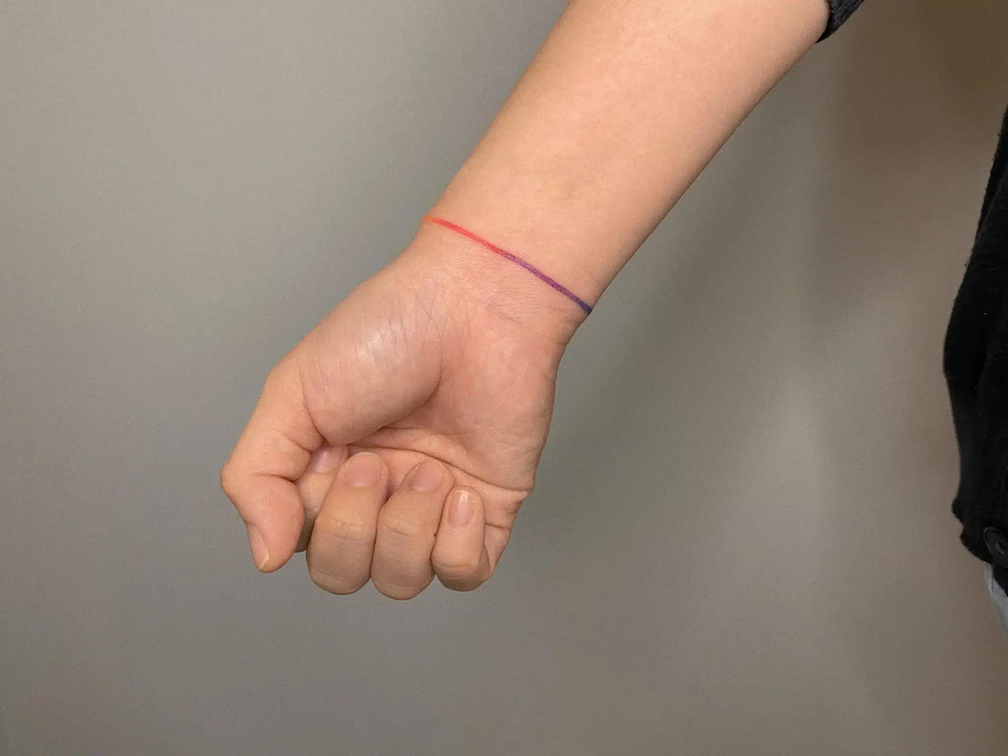 thin red line circling bracelet tattoo