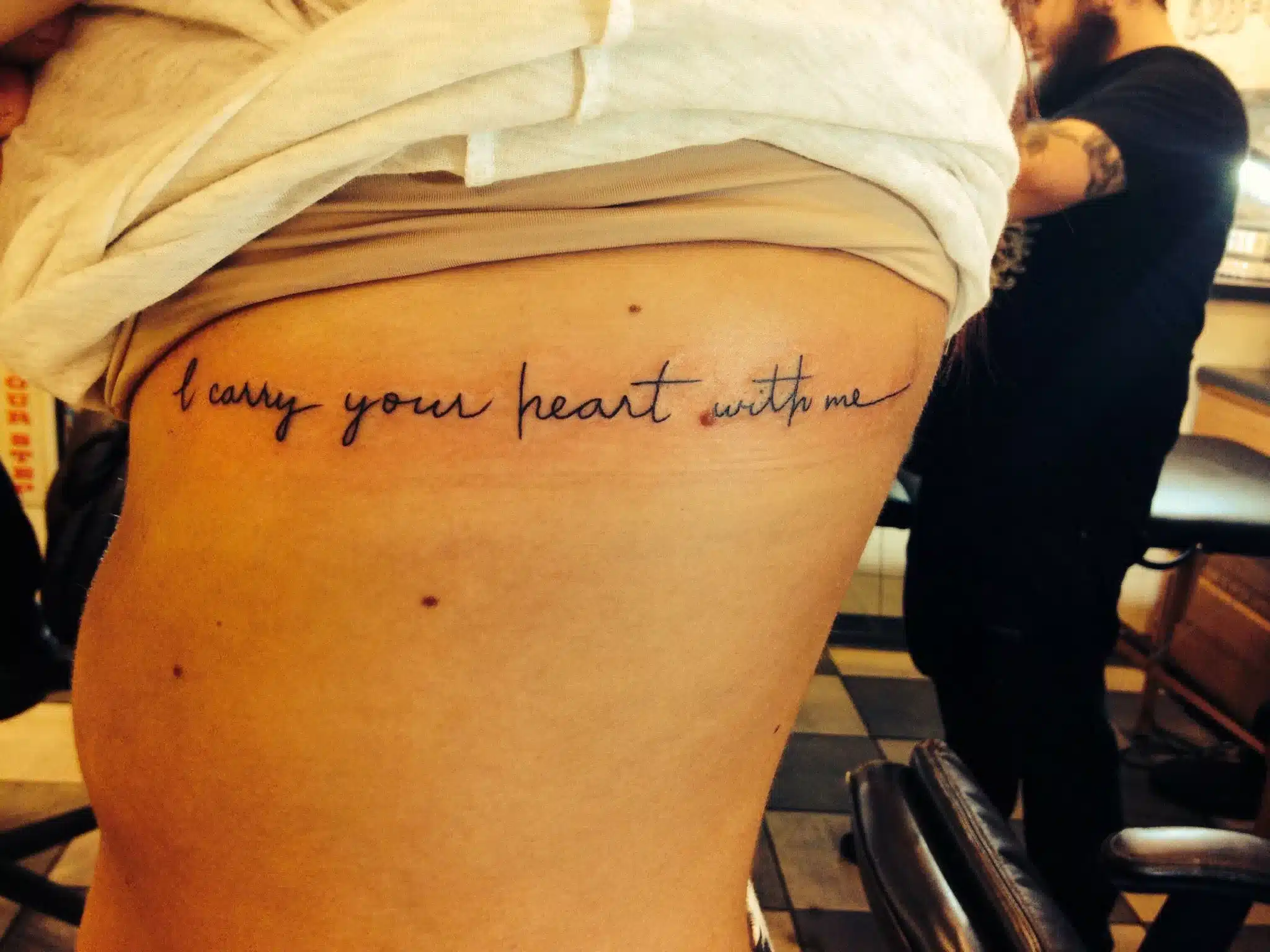 Tiny word tattoo near the rib