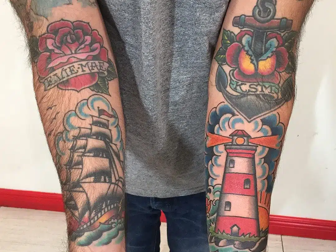 Classic color old-school tattoo with an anchor and rose on a forearm