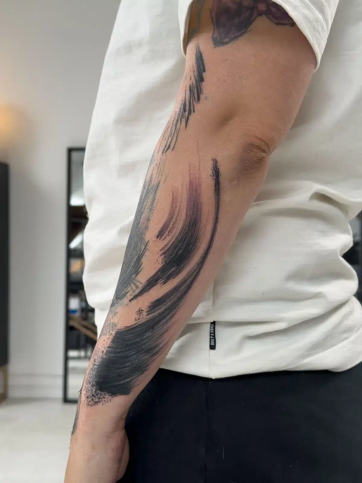 An abstract painterly black tattoo